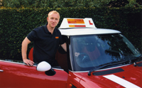 Paul Hobbs with the red mini cooper driving instruction car